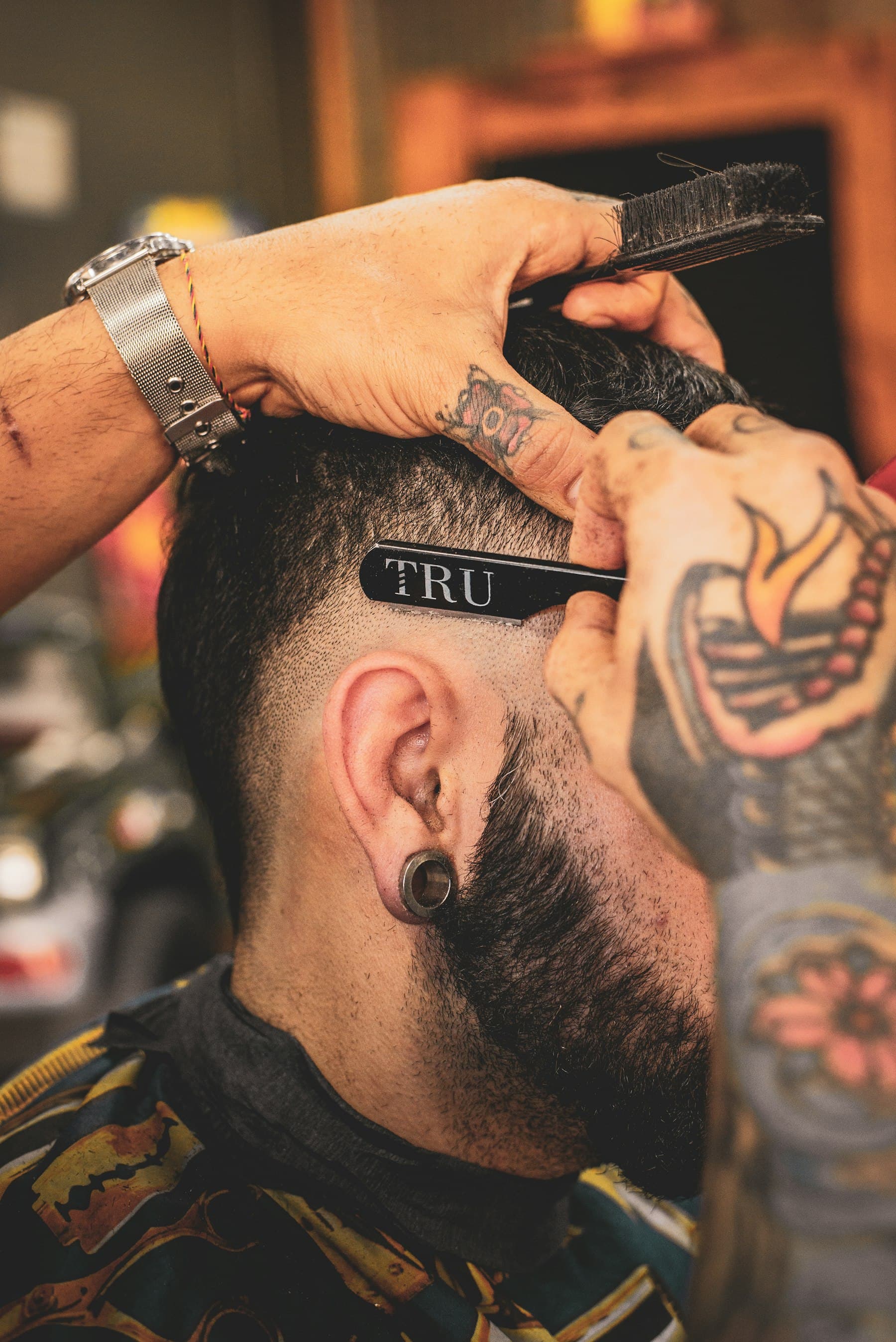 Barbero perfilando un fade con máquina